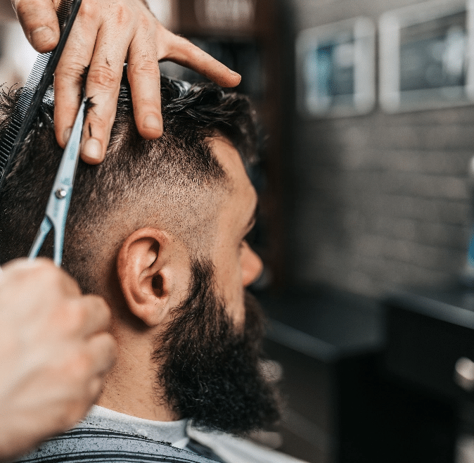 Barber Using Scissors on a Mans Hair